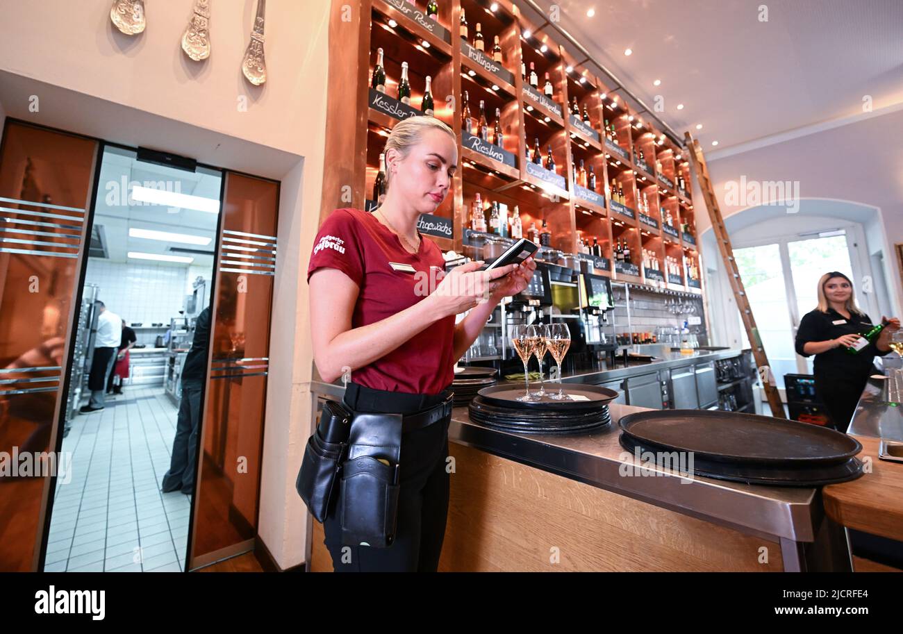 Stuttgart, Germany. 15th June, 2022. A waitress enters an order into her billing device at a restaurant in Stuttgart. Restaurateurs in the southwest plead for a permanent reduction of the value-added tax in their industry. (to dpa 'Gastronomen: Bei Mehrwertsteuer dauerhaft entlastet werden') Credit: Bernd Weißbrod/dpa/Alamy Live News Stock Photo