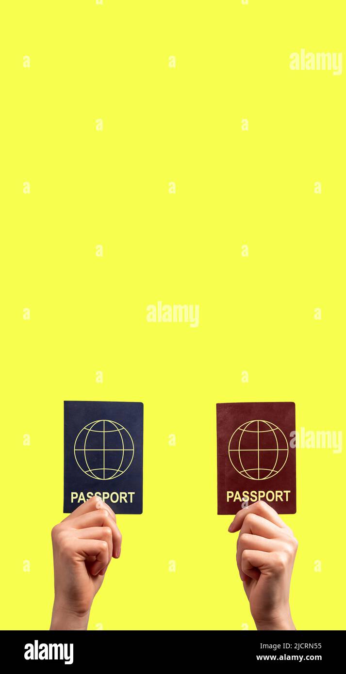 Banner with hands showing two passports. Immigration, multiple, dual citizenship concept. Identity, nationality verification. Copy space on yellow background. High quality photo Stock Photo