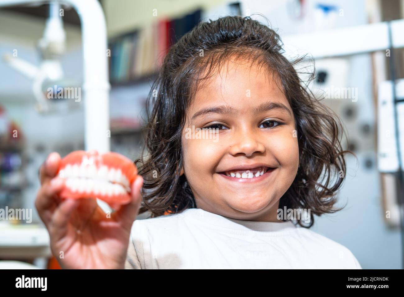 Happy smiling kid showing dentures by looking at camera - concept of childrens healthy oral or dental care treatment. Stock Photo