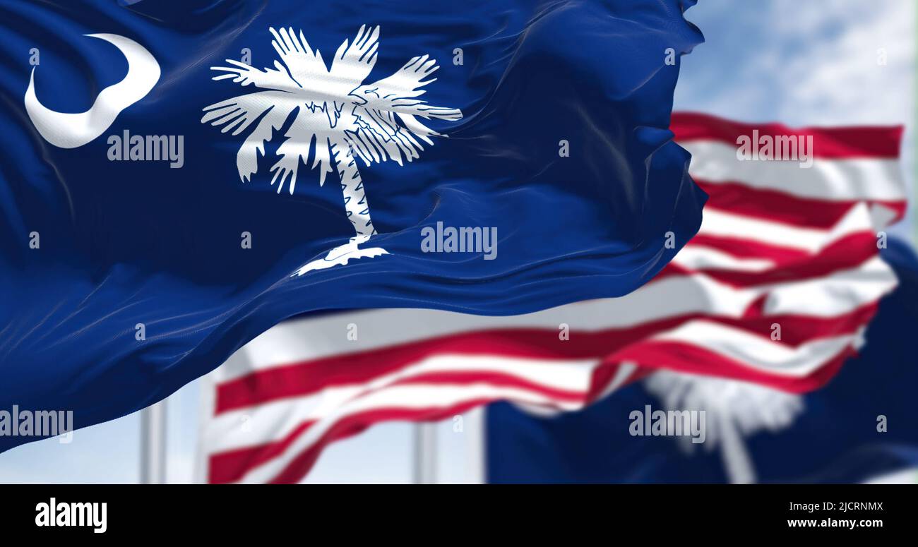 The South Carolina state flag waving along with the national flag of the United States of America. South Carolina is a state in the coastal Southeaste Stock Photo