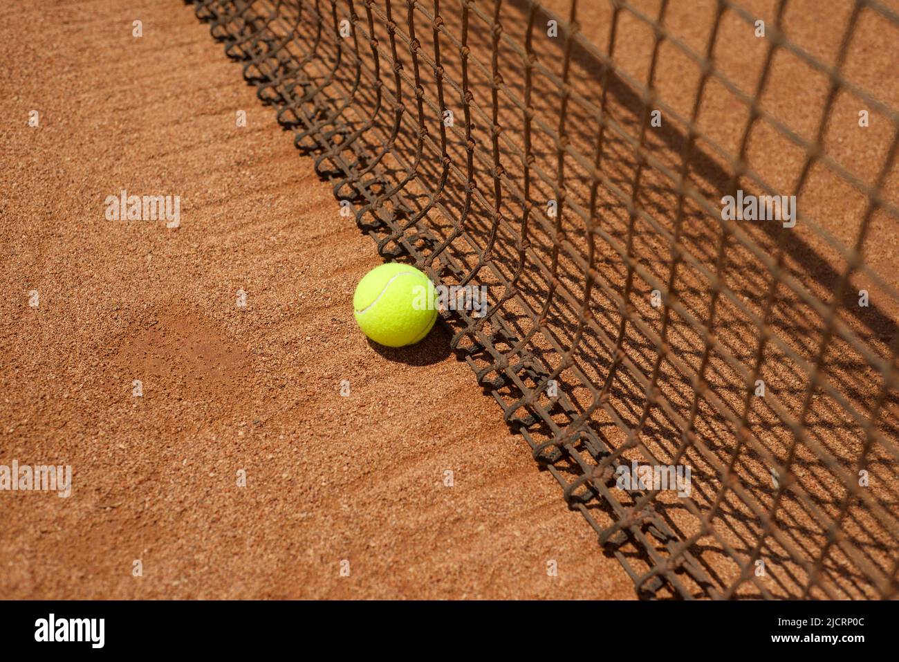 Tennis backgrounds. Ball on clay court and tennis net. Copy space for