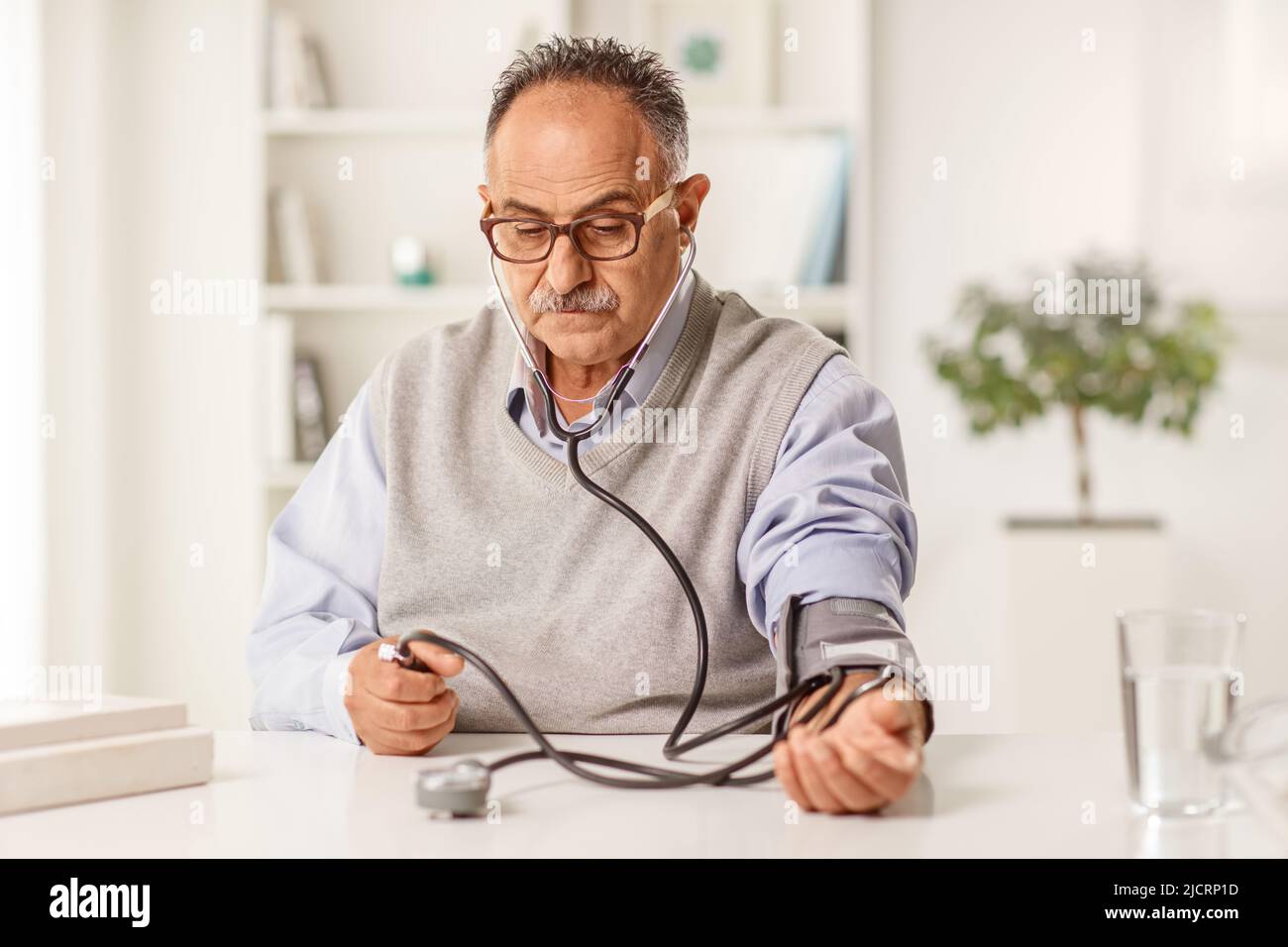 Mature man measuring blood pressure at home Stock Photo