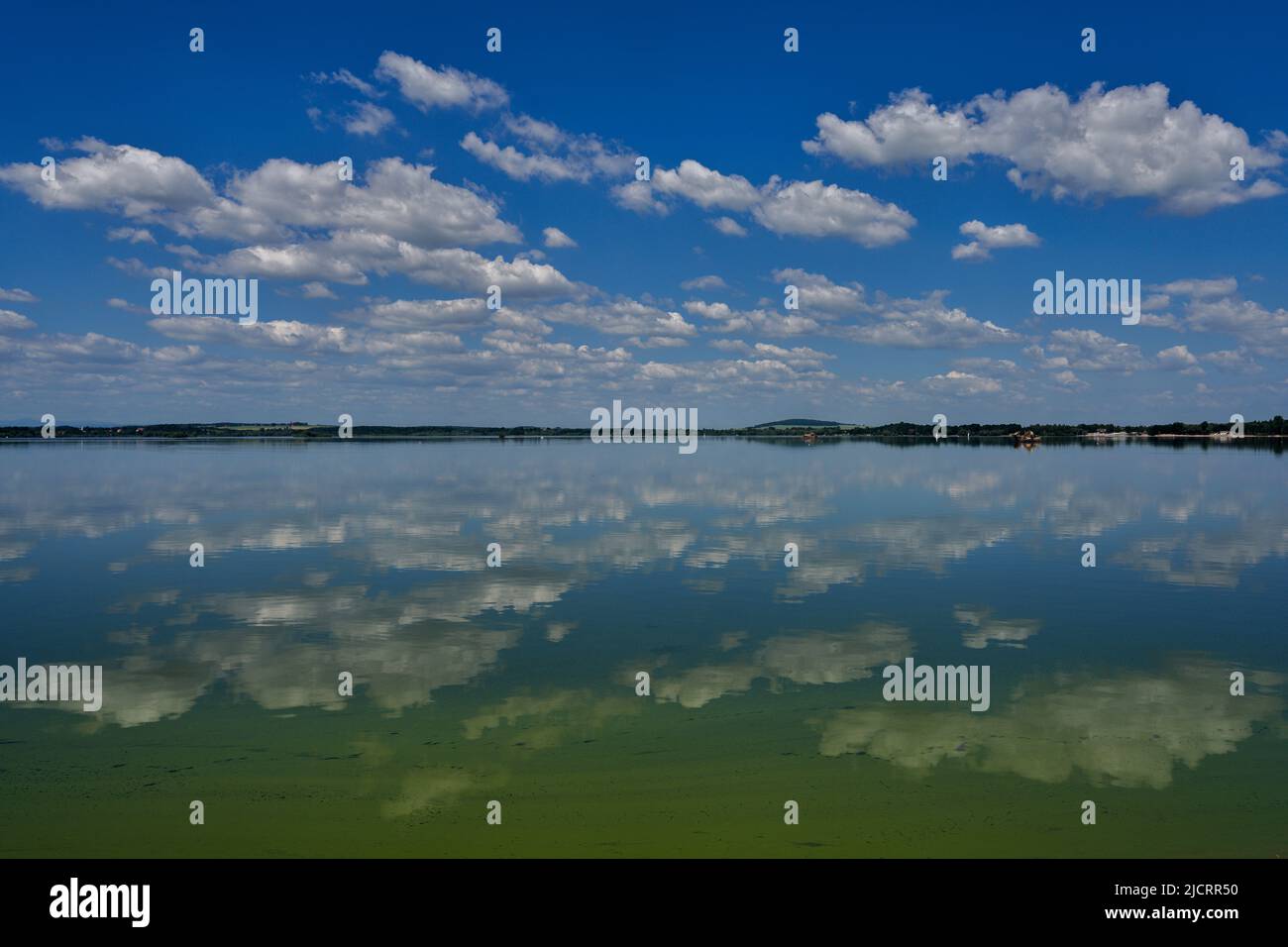 Blue sky with white clouds reflecting on the water Stock Photo - Alamy