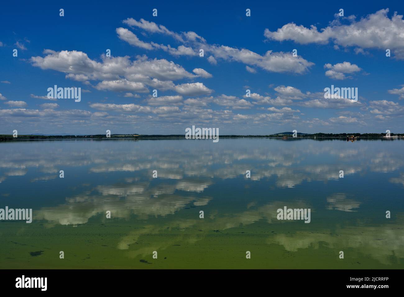 Blue sky with white clouds reflecting on the water Stock Photo - Alamy
