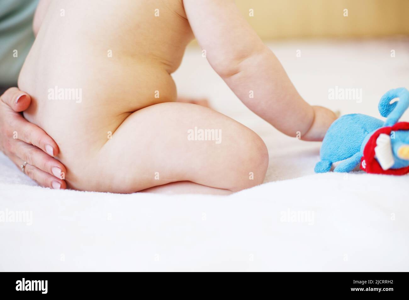 Mother and baby. Mom's love and tenderness. Mother massaging baby in the bed at home Stock Photo