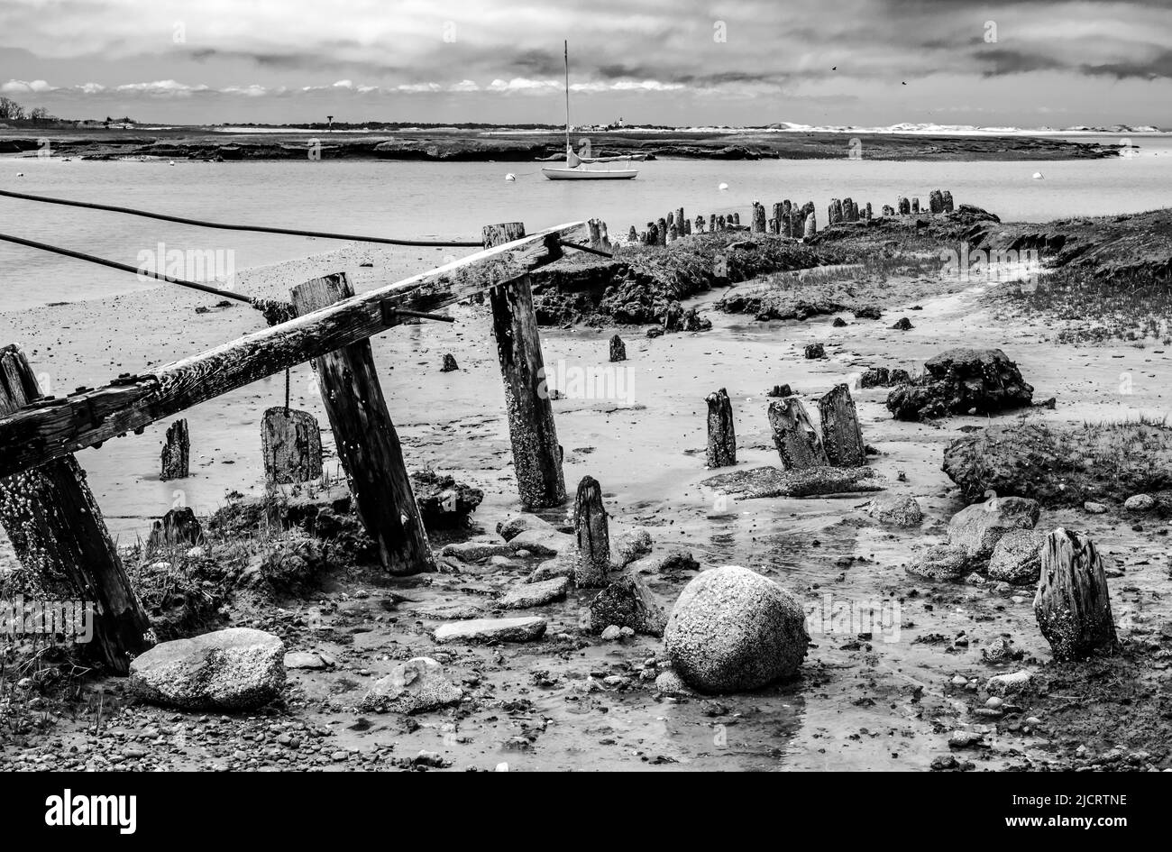 What is left of this very old wharf, and an old round ballast stone shows what is a reminder of all the old ships that use to come in here. Stock Photo