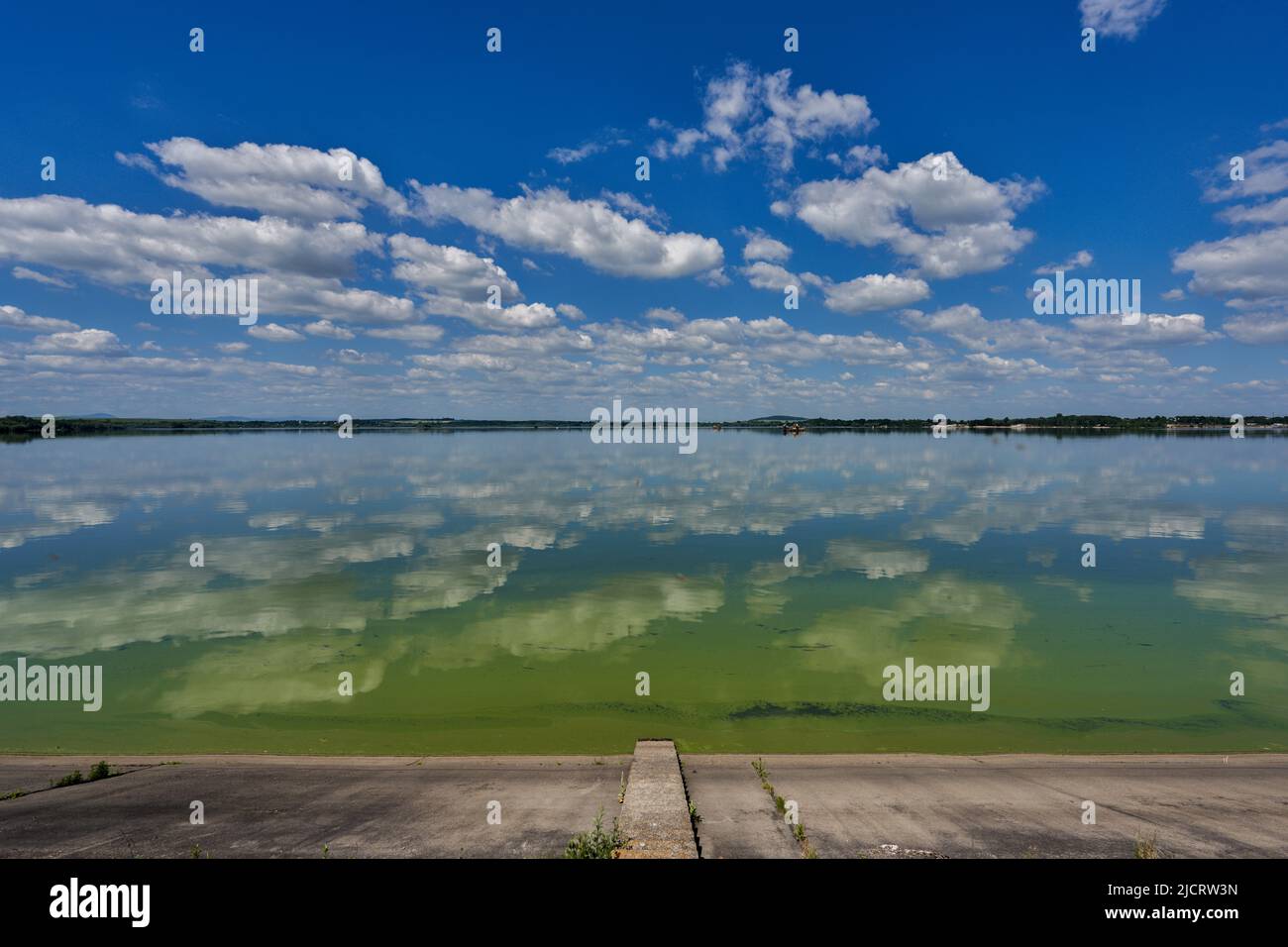 Blue sky with white clouds reflecting on the water Stock Photo - Alamy