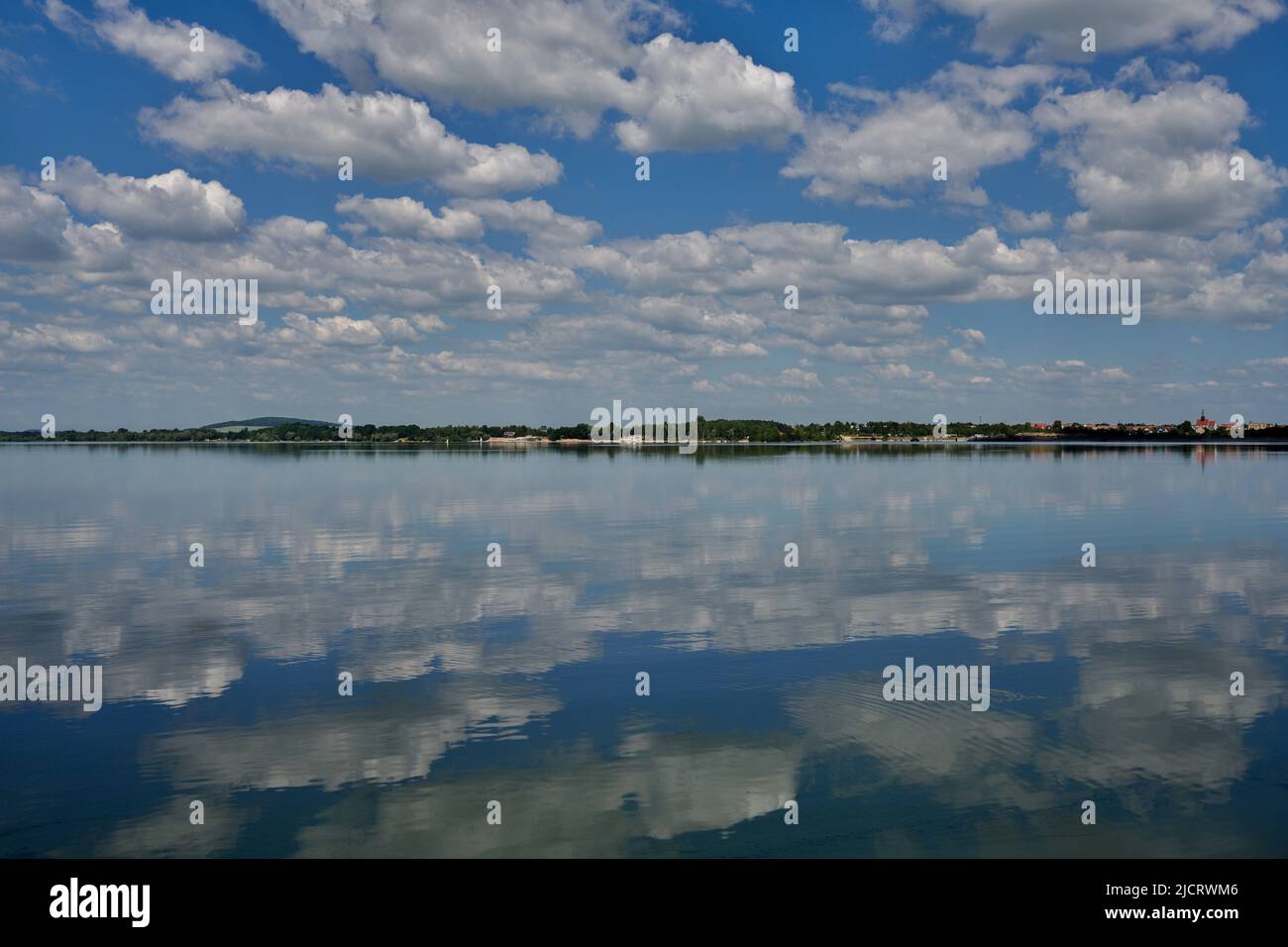 Blue sky with white clouds reflecting on the water Stock Photo - Alamy