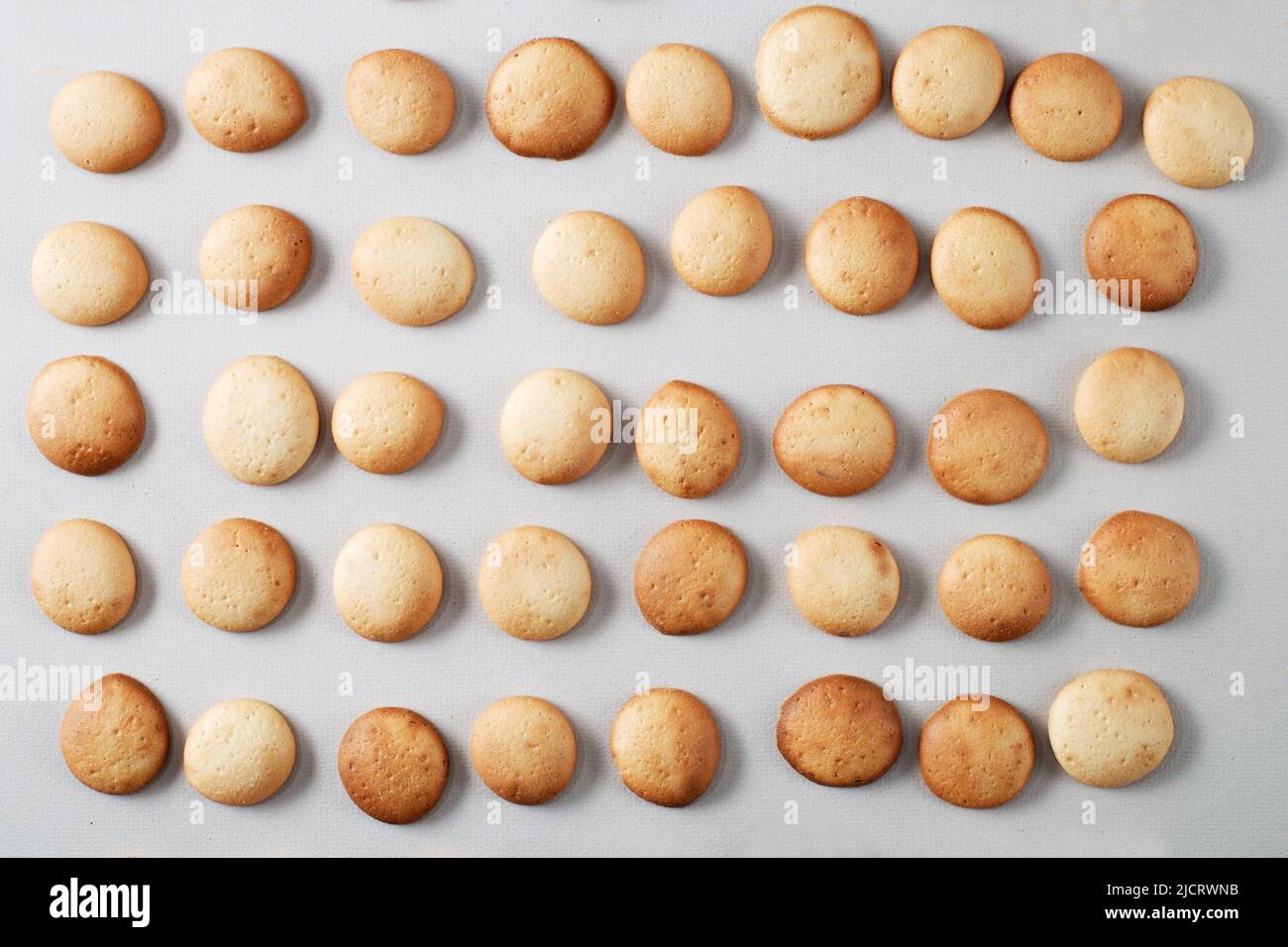 A pattern of a small pancakes. Background from orange toasted round biscuits. home bakery Stock Photo