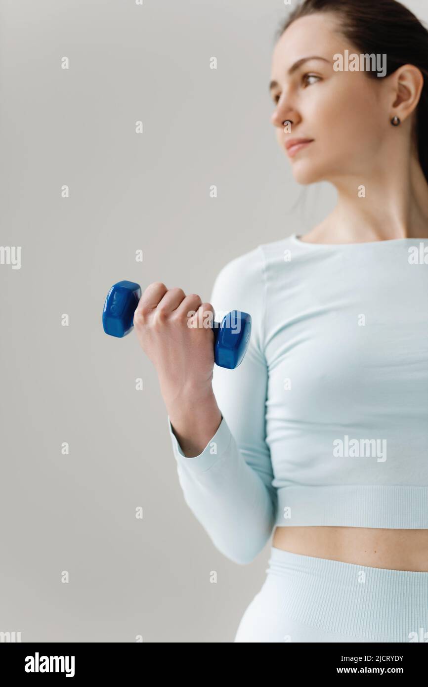 Closeup of beautiful fit woman exercising with dumbbell. Stock Photo