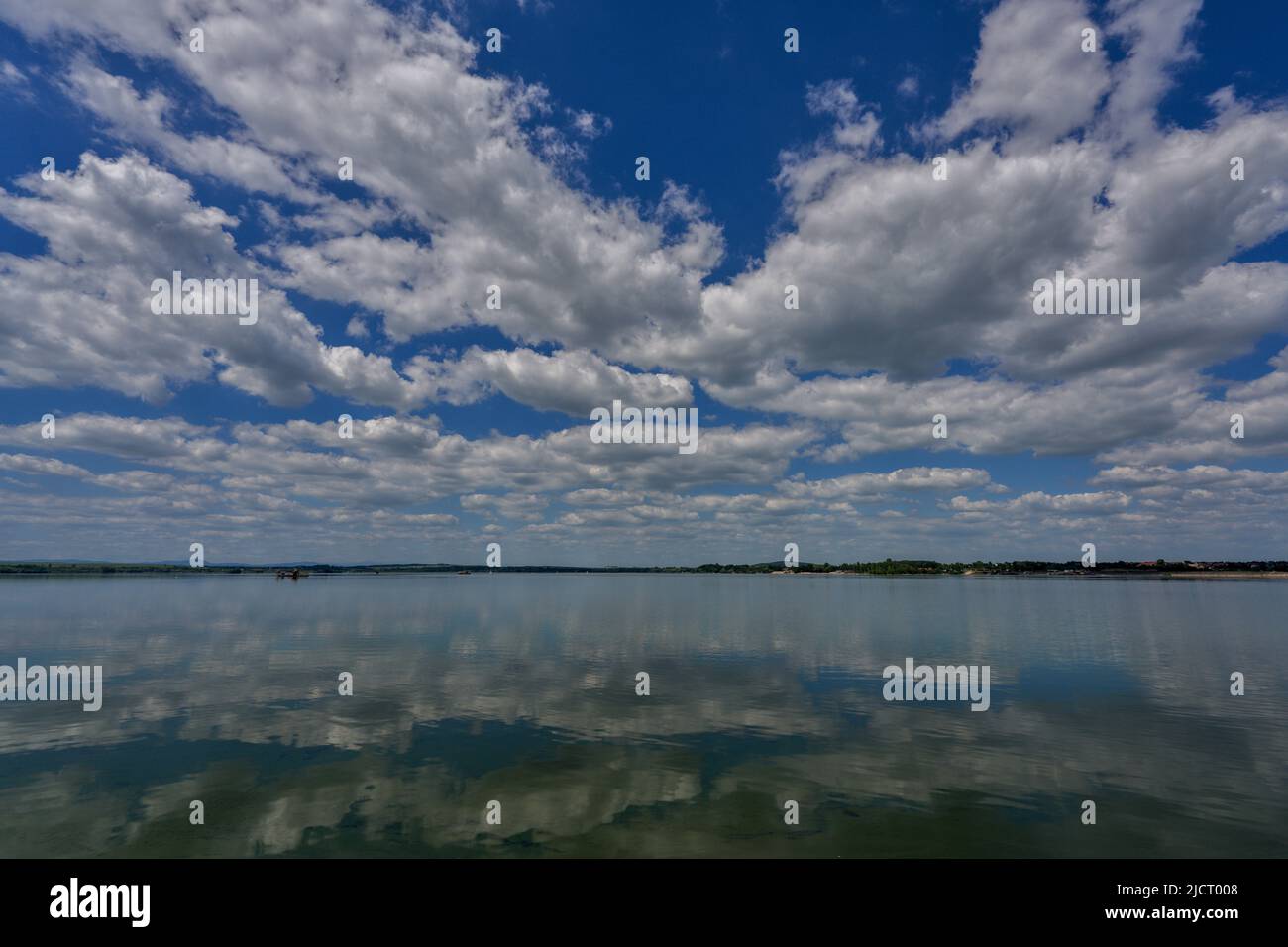 Blue sky with white clouds reflecting on the water Stock Photo - Alamy