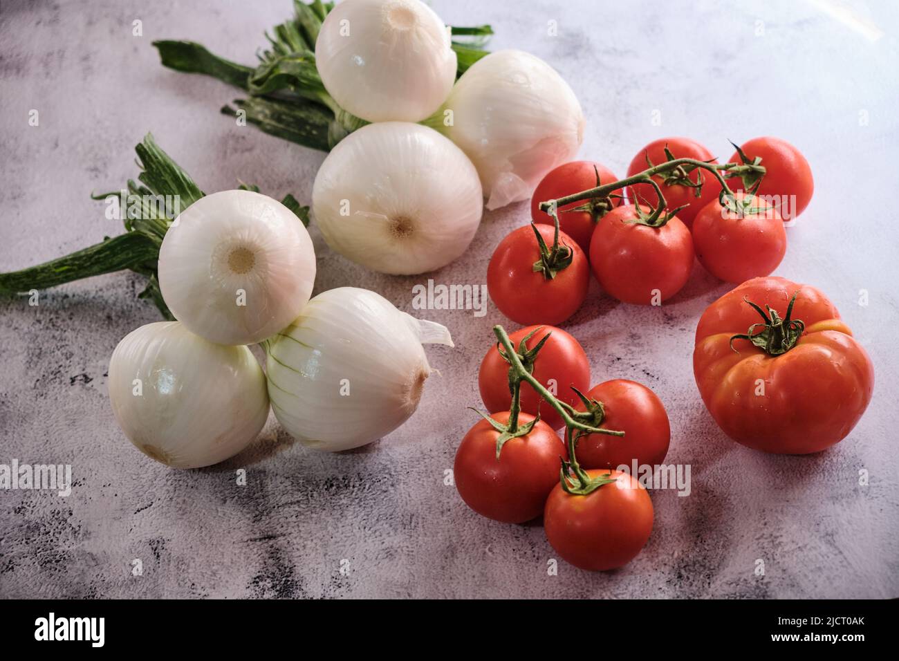 Organic red onions and tomatoes, complements for simple and anticancer salads. Stock Photo