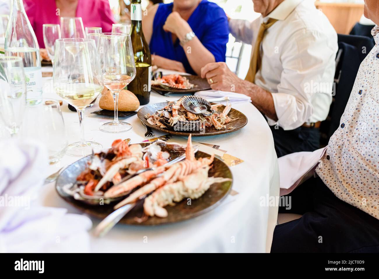 Diners have just had a seafood feast in a restaurant, plates full of leftovers. Stock Photo