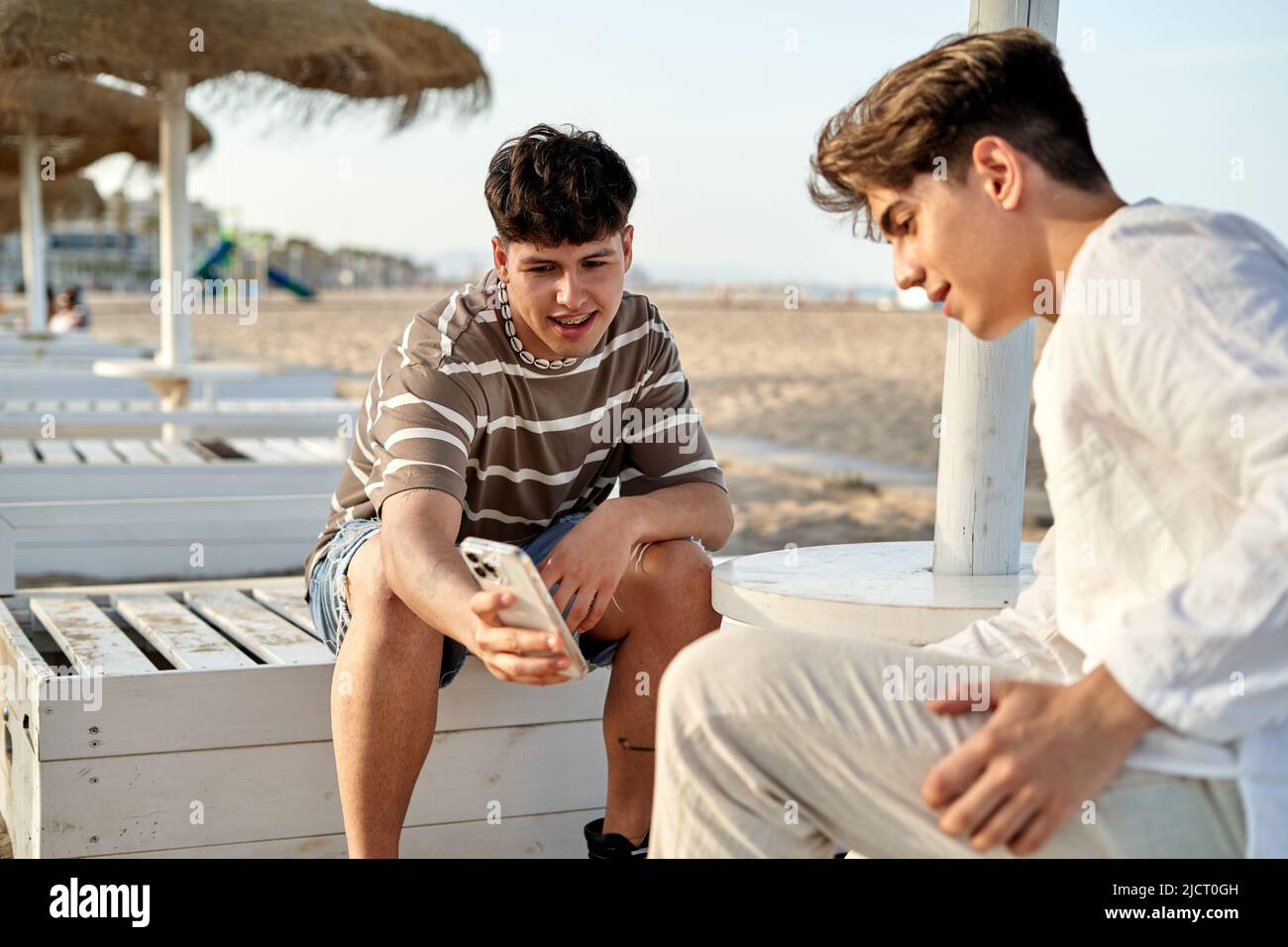 gay couple outdoors having fun and using looking at mobile. Stock Photo