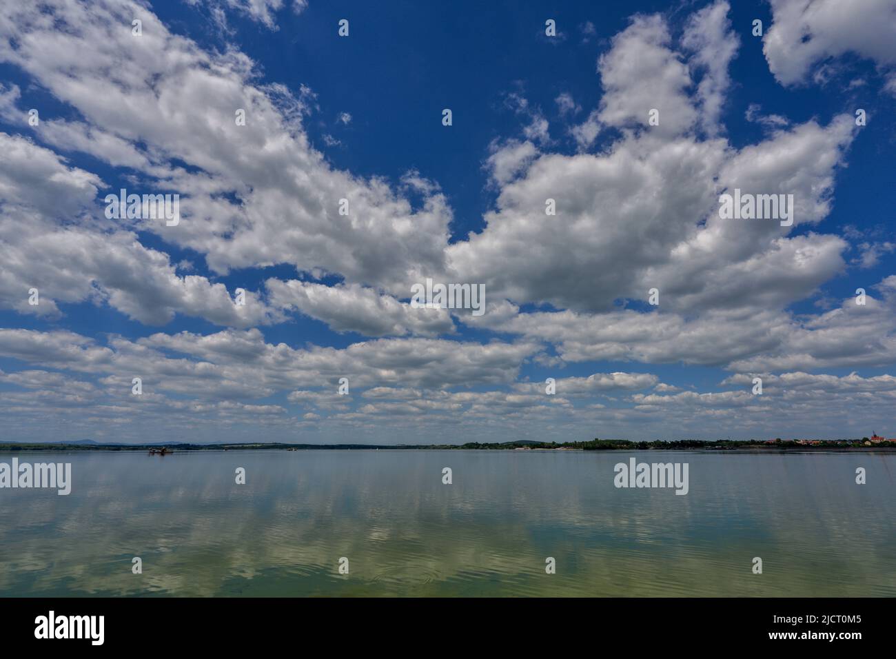 Blue sky with white clouds reflecting on the water Stock Photo - Alamy