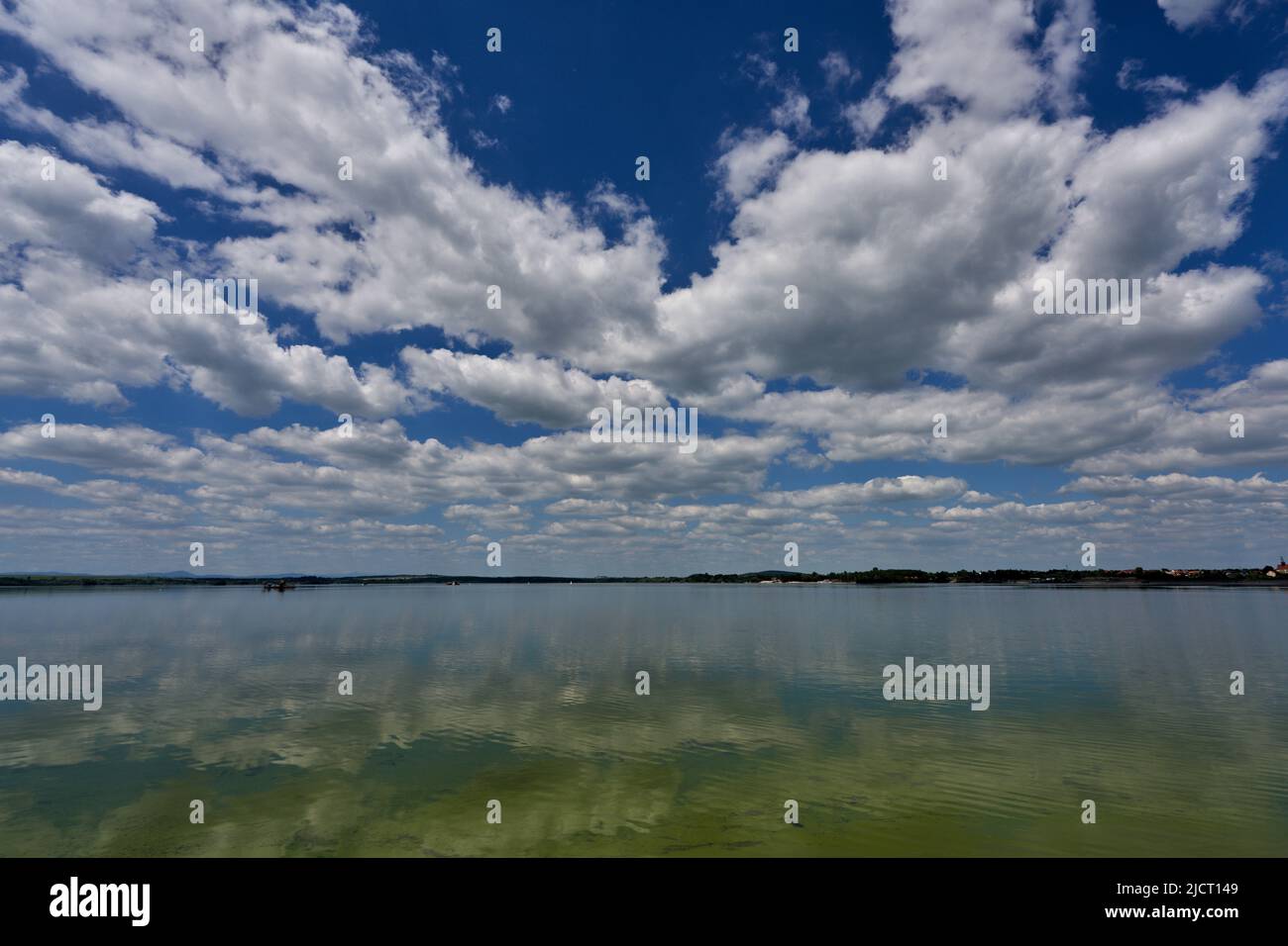 Blue sky with white clouds reflecting on the water Stock Photo - Alamy