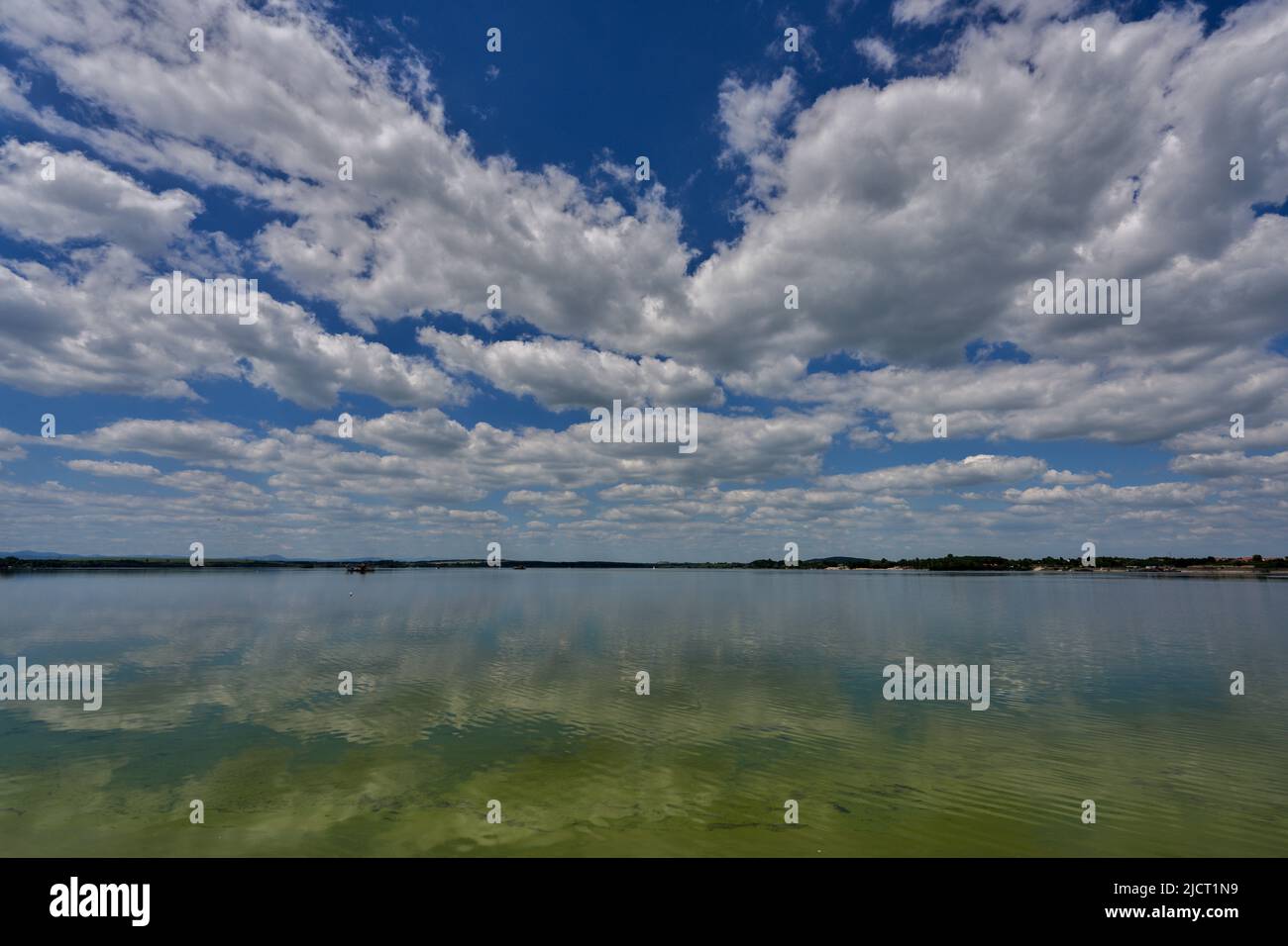 Blue sky with white clouds reflecting on the water Stock Photo - Alamy