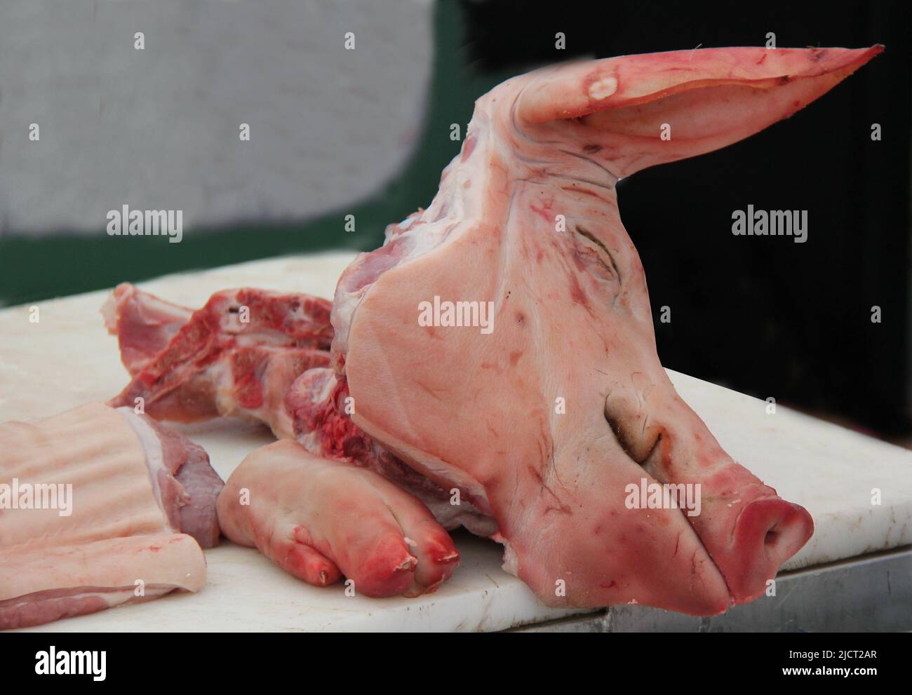 A Pigs Head Cut Up on a Butchers Meat Block. Stock Photo