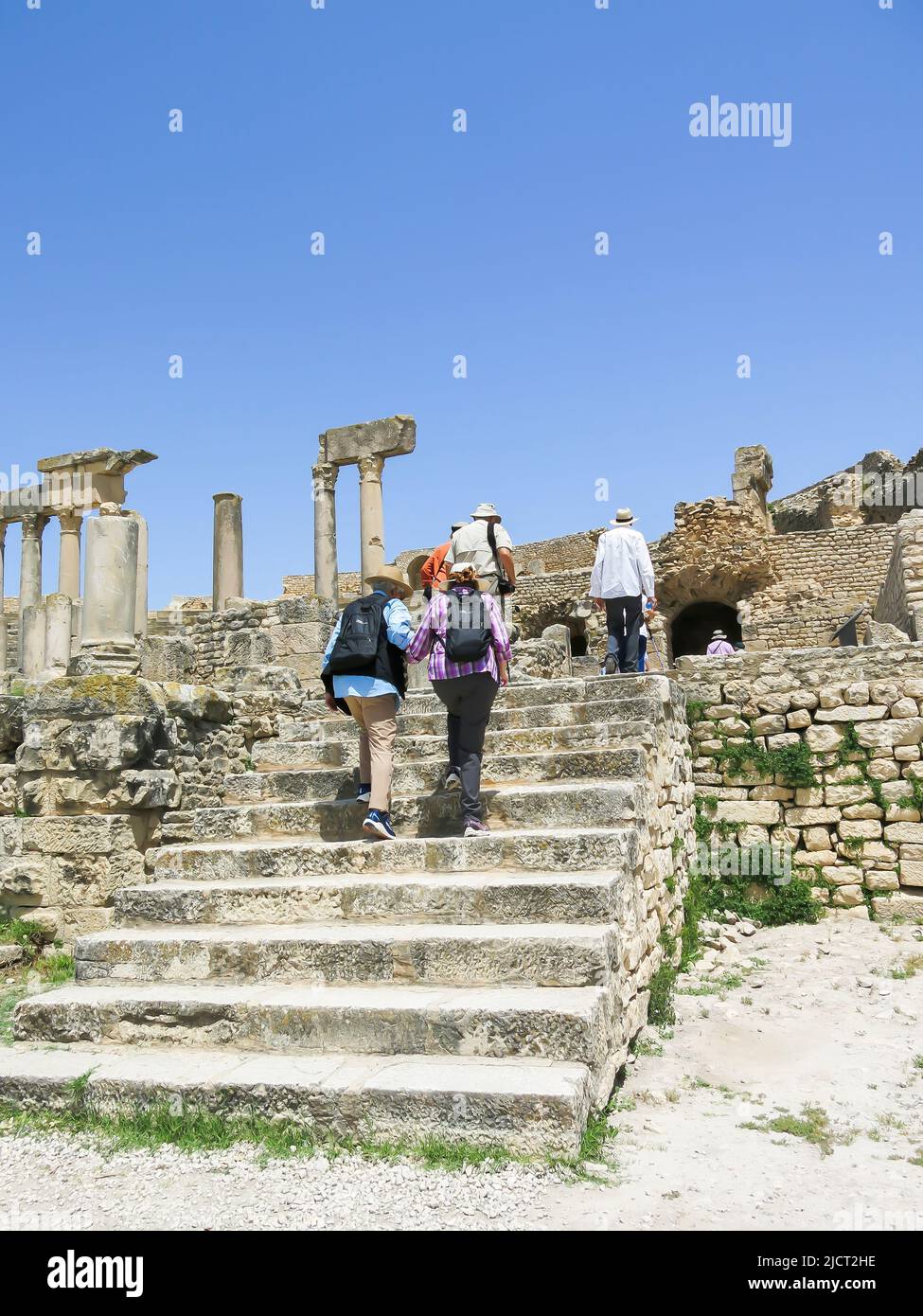 Tourists Entering Dougga Ruins to Explore Ancient Roman City Stock Photo