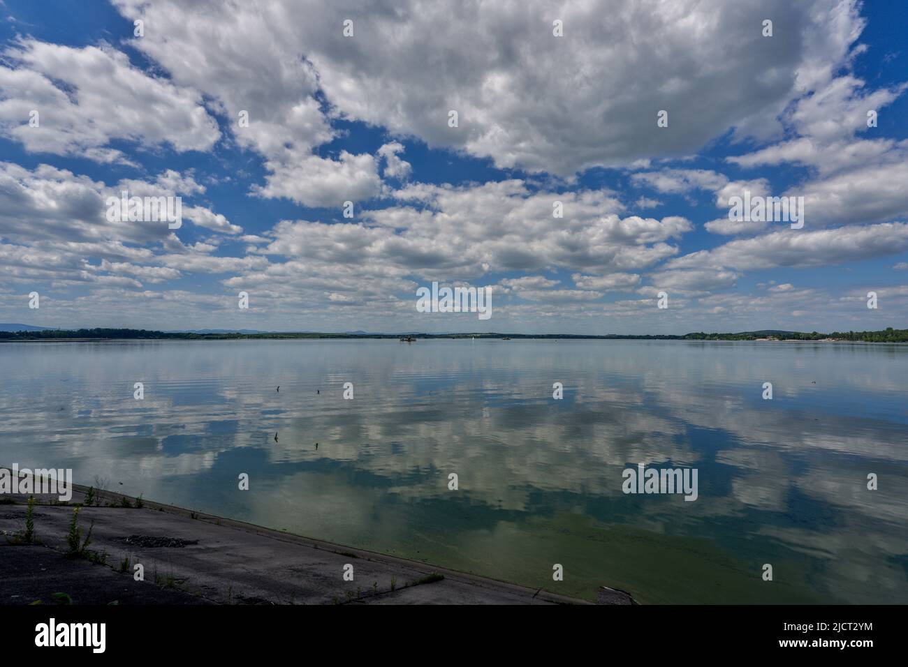 Blue sky with white clouds reflecting on the water Stock Photo - Alamy