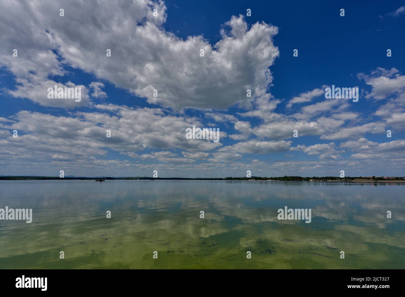 Blue sky with white clouds reflecting on the water Stock Photo - Alamy