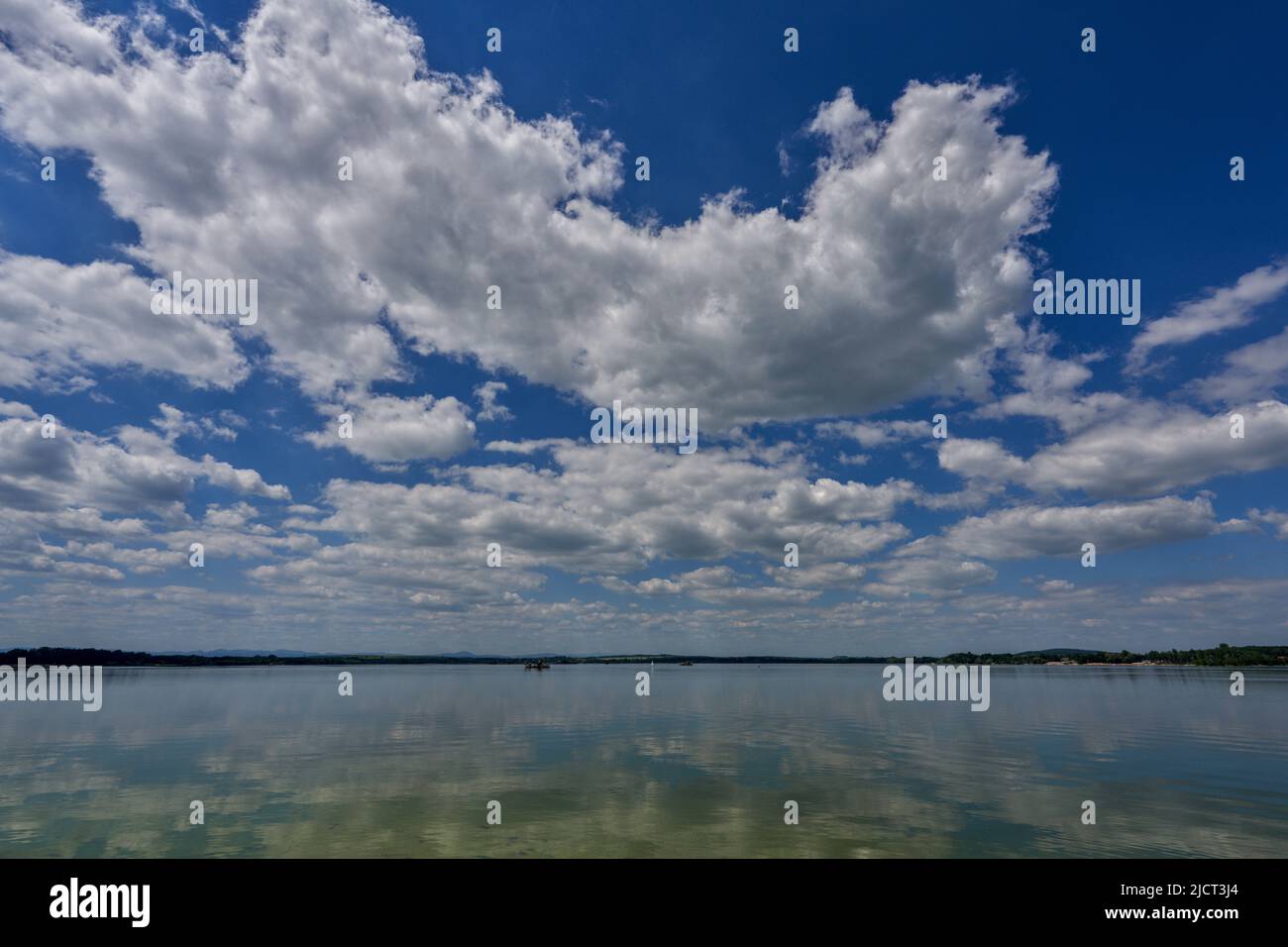 Blue sky with white clouds reflecting on the water Stock Photo - Alamy