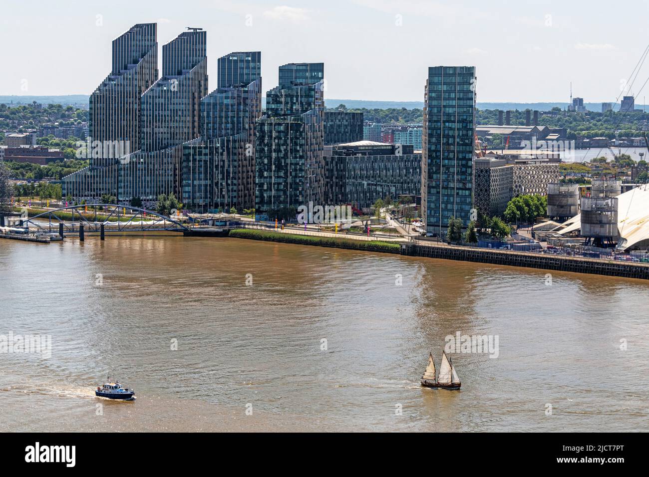 A Lifeboat and an old Sailing cutter pass Greenwich Peninsular on the Rover Thames in East London. Stock Photo