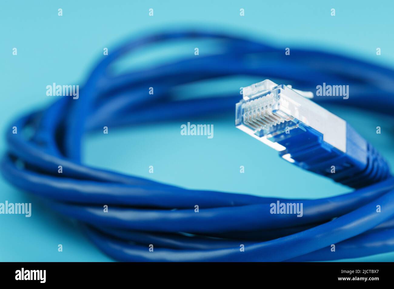 A coil of RJ45 Cat.6 Network Cable isolated on a blue