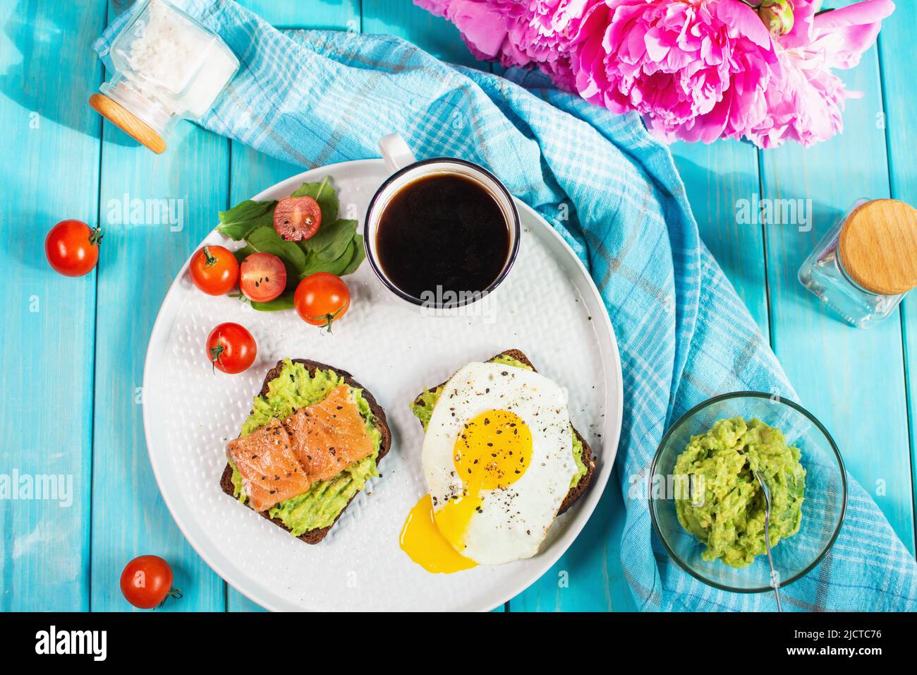 sandwich with fried egg, avocado and salted salmon with a cup of aromatic coffee for breakfast. Top view Stock Photo