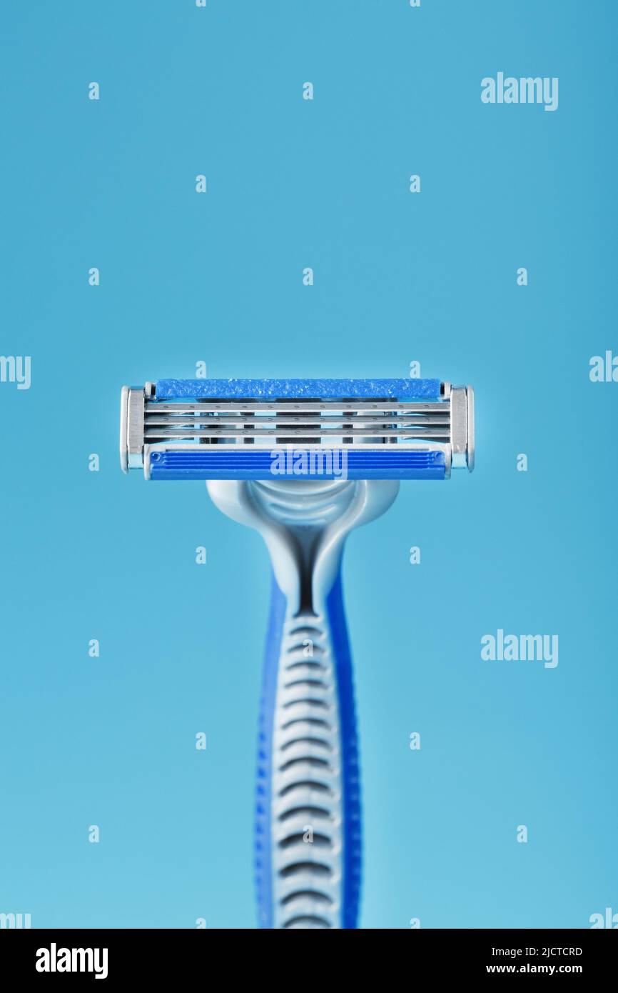 Three shaving machines on a blue background with free space, top view Stock Photo