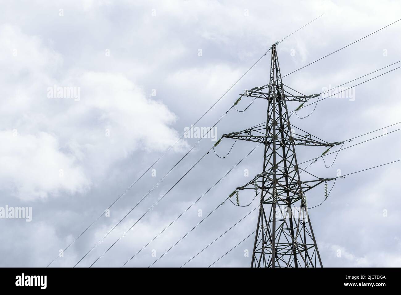 View of a high-voltage overhead power line. Electricity pole on a power line. Stock Photo