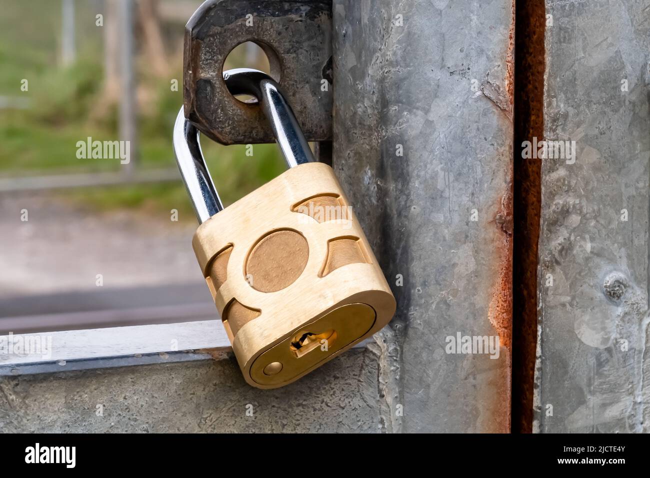 close up of padlock, with hasp and clasp holding gate shut, conceptual