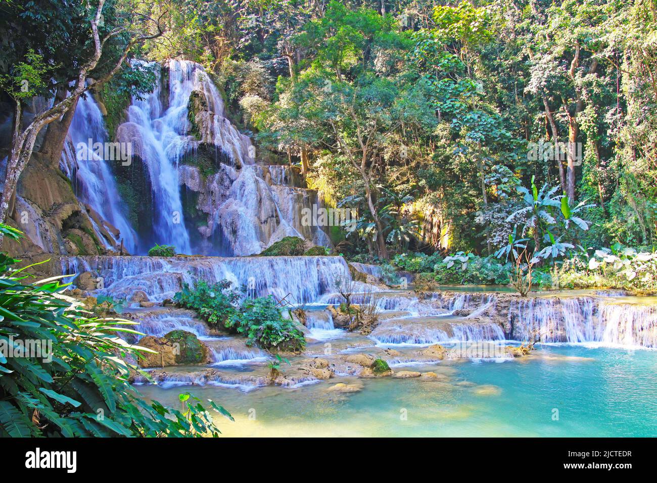 Beautiful secluded idyllic lonely wild jungle forest landscape lagoon, waterfall rock cascade, turquoise natural plunge pool - Kuang Si, Luang Prabang Stock Photo