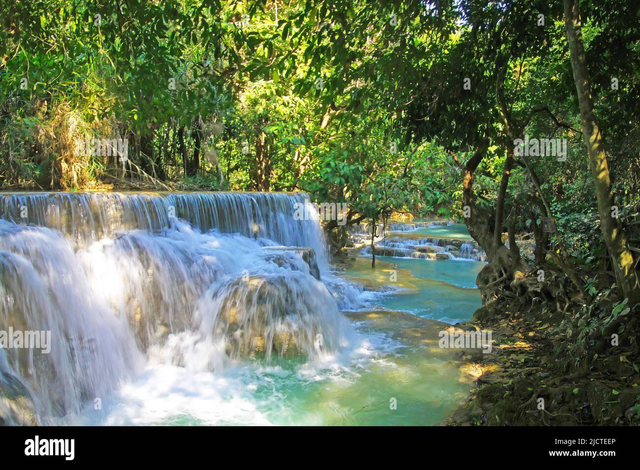 Beautiful secluded lonely tropical waterfall landscape, green jungle forest, rock cascade, blue turquoise river  - Kuang Si, Luang Prabang, Laos Stock Photo
