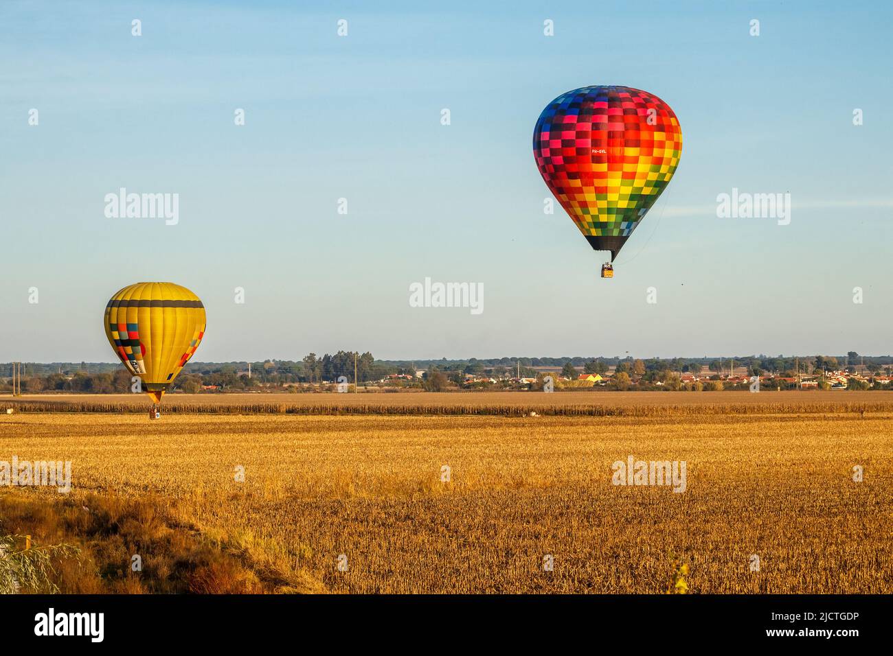 Coruche, Portugal - November 13, 2021: 2 Hot air balloons flying over the cornfields outside Coruche in Portugal, during the Ballooning Festival. Stock Photo