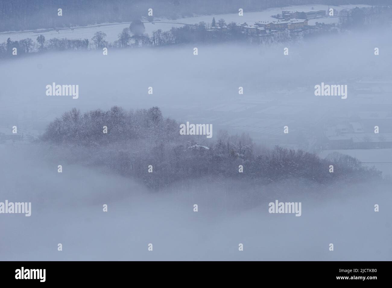 Brianza covered in fresh snow and fog in the early morning, near the town of Brivio, Italy - December 2021. Stock Photo