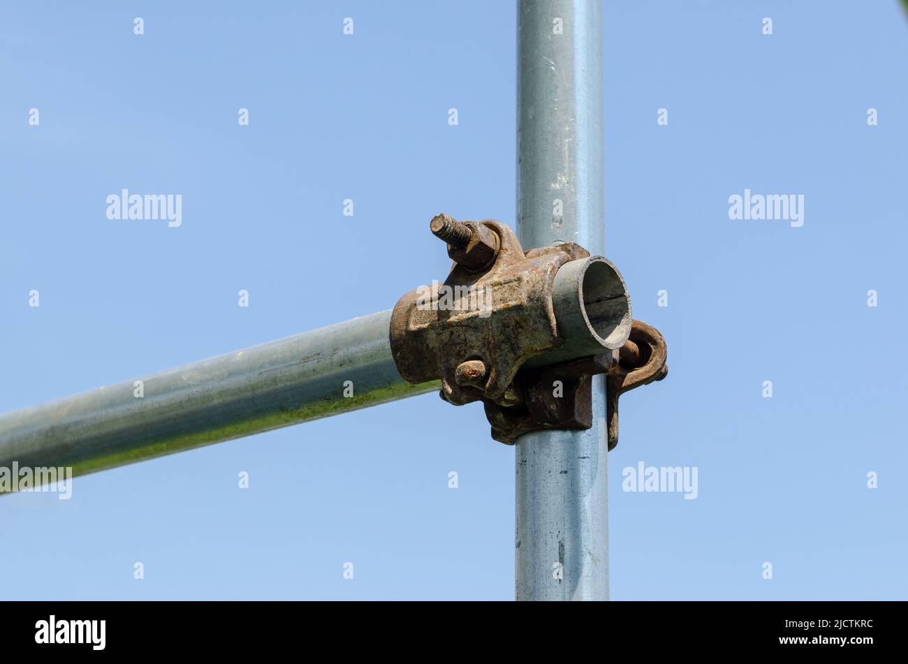 Scaffolding construction: detail with load-bearing structure in galvanized steel and joints joined by nuts and bolts. Stock Photo