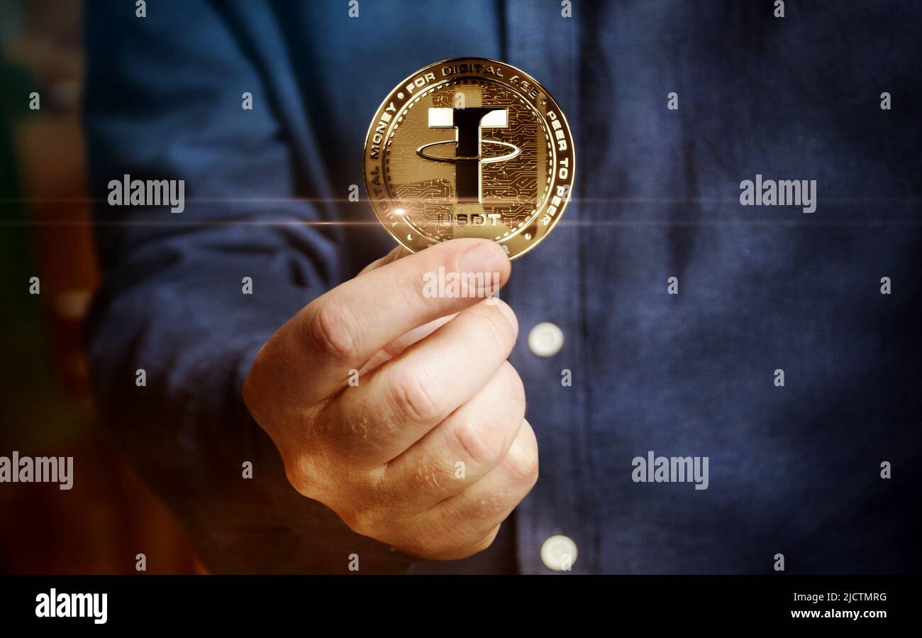 Tether USDT stablecoin cryptocurrency golden coin in hand abstract concept Stock Photo