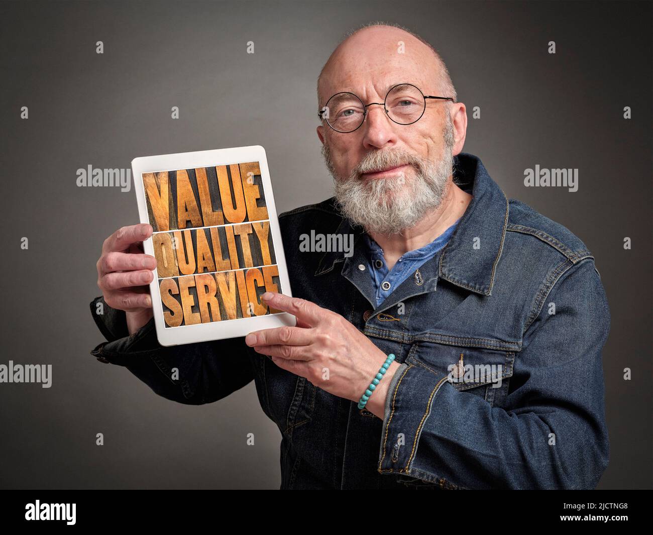 value, quality and service - older businessman sharing message or mission statement on a digital table, company core values concept Stock Photo
