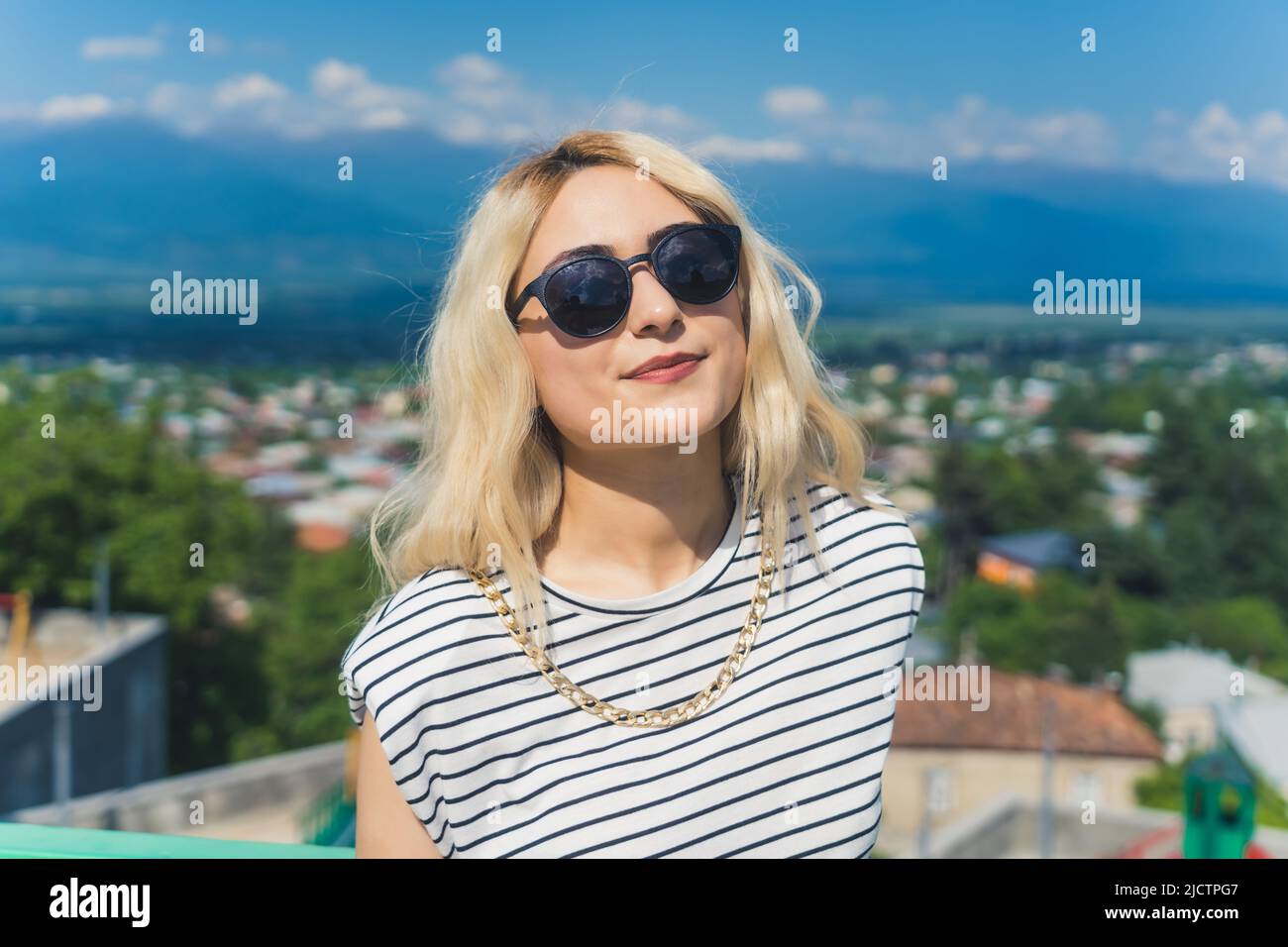 pretty Caucasian girl with sunglasses on the beautiful town background, medium closeup. High quality photo Stock Photo