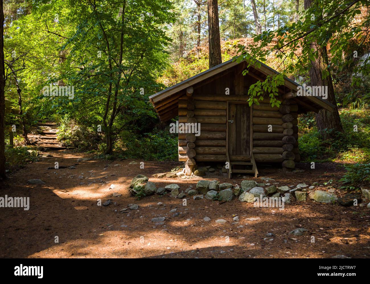 Wood cabin in forest. Vintage house with stairs and nature path Stock Photo