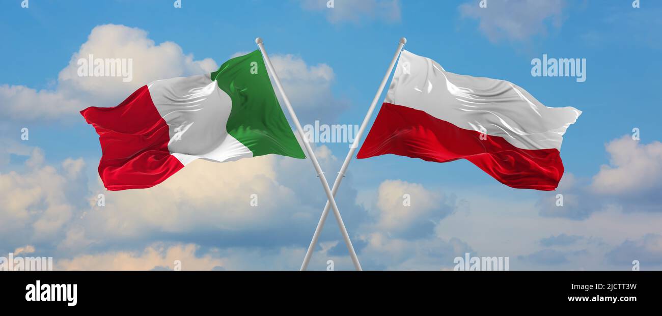 two crossed flags Italy and Poland waving in wind at cloudy sky ...