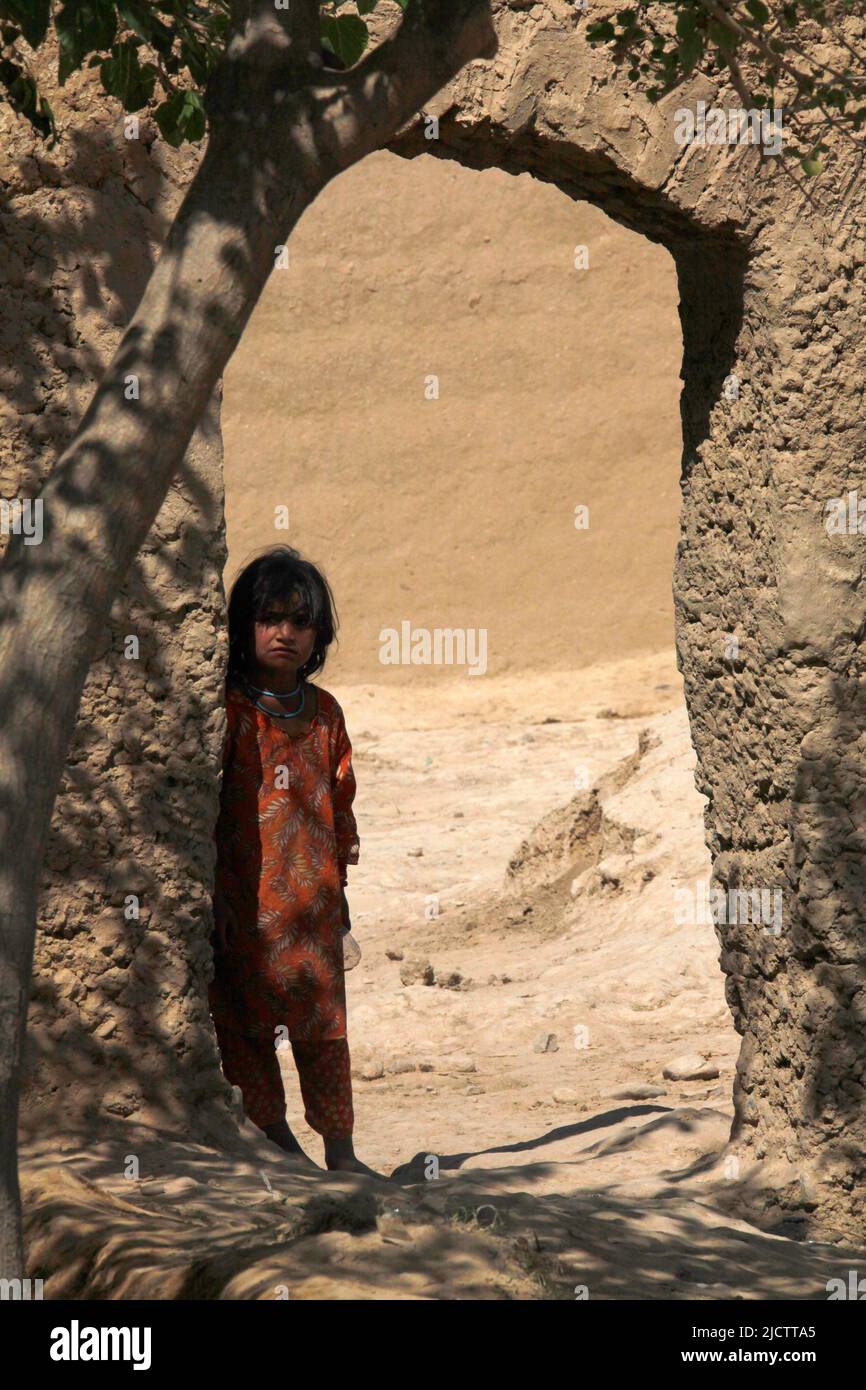 A local Afghan child peeks around a door opening to see what U.S. Marines with 1st Battalion, 8th Marine Regiment, Regimental Combat Team 6, are doing Stock Photo