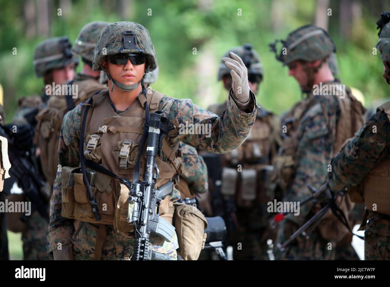 A U.S. Marine with 3rd Squad, 3rd Platoon, Bravo Company, 1st Battalion, 8th Marine Regiment (1/8), 2D Marine Division, calls over a fellow squad memb Stock Photo