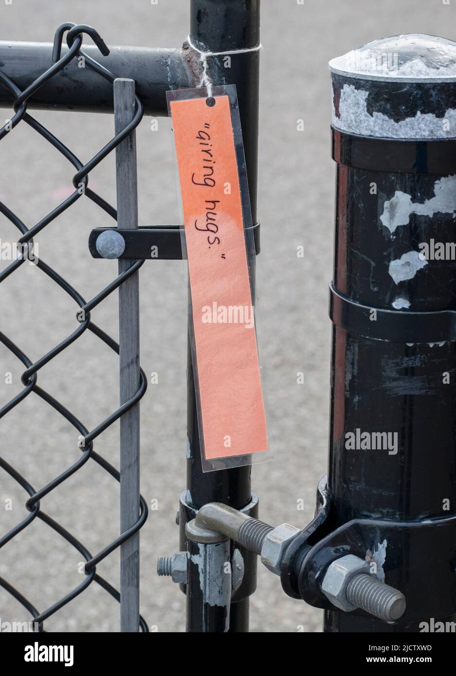 A laminated note card (giving hug)is hanging from a chain link fence,  Ontario, Canada - stock photography Stock Photo - Alamy
