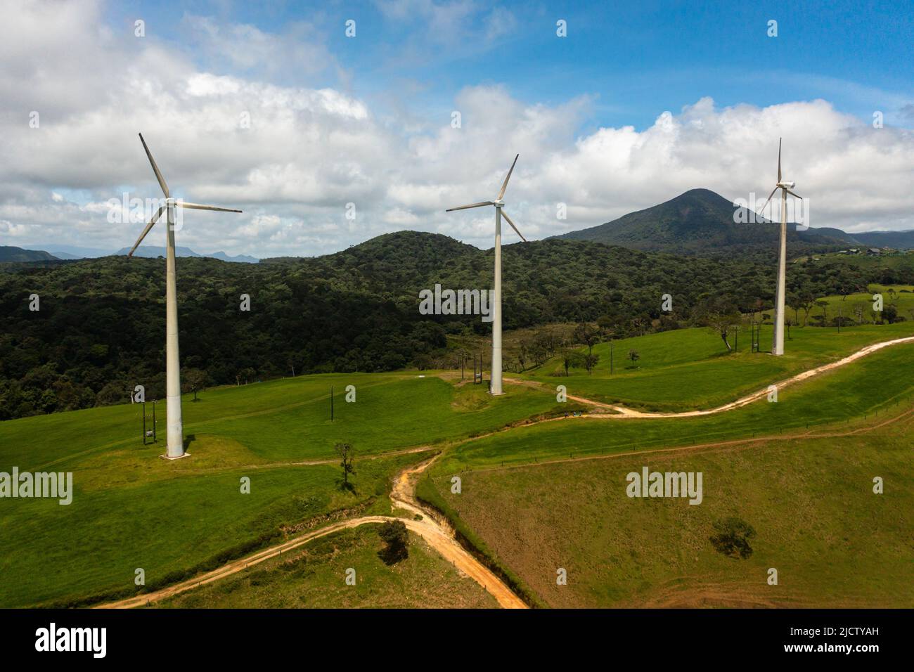 Group of wind turbines among green pastures and hills. Wind power plant. Ambewela, Sri Lanka