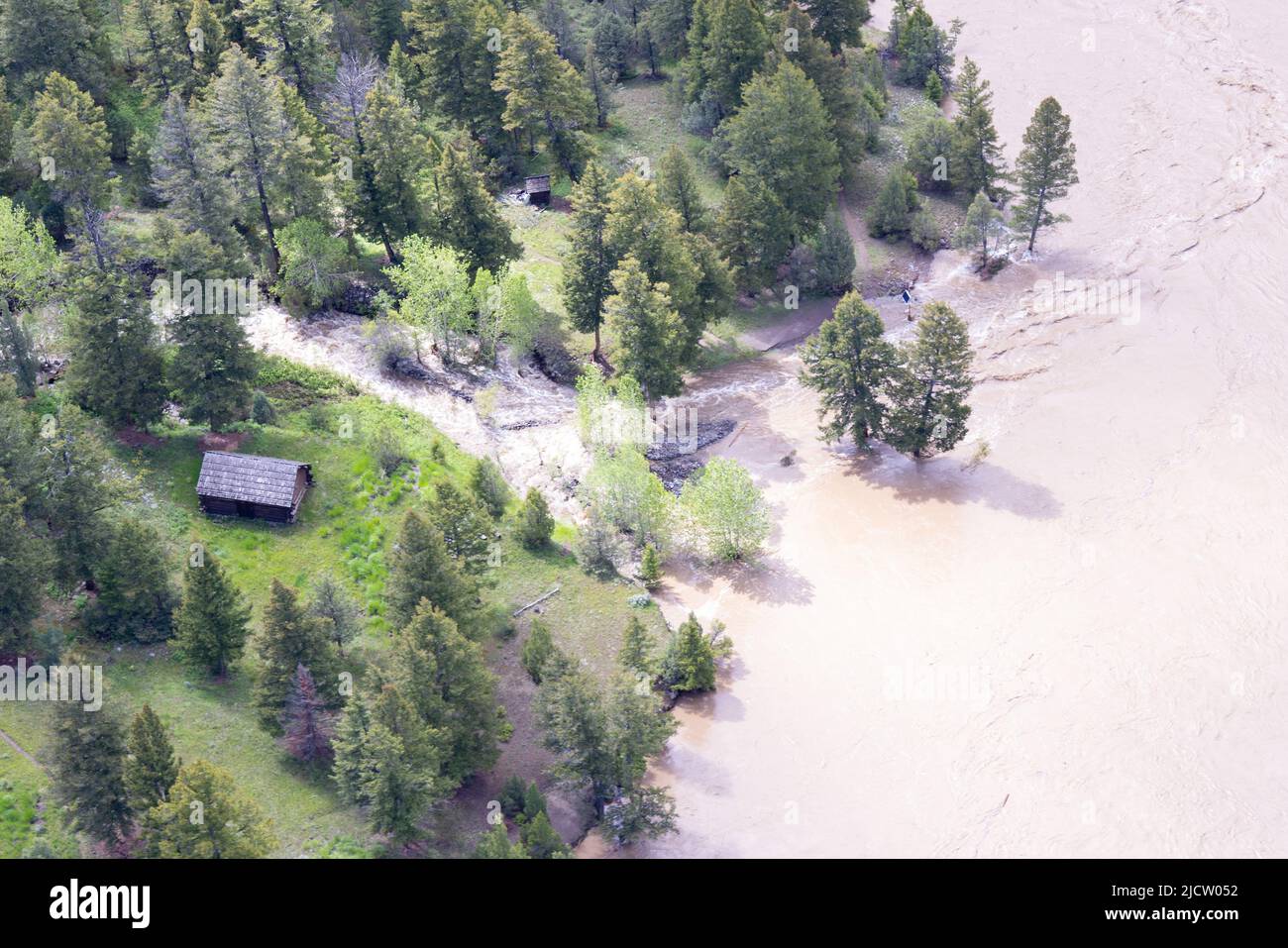 Yellowstone, United States. 13th June, 2022. The Lower Blacktail Patrol Cabin is washed away into the Yellowstone River after record rains and snow melt caused destructive floods closing Yellowstone National Park at the start of the busy season, June 13, 2022 in Yellowstone, Montana. Credit: Jacob W. Frank/NPS Photo/Alamy Live News Stock Photo