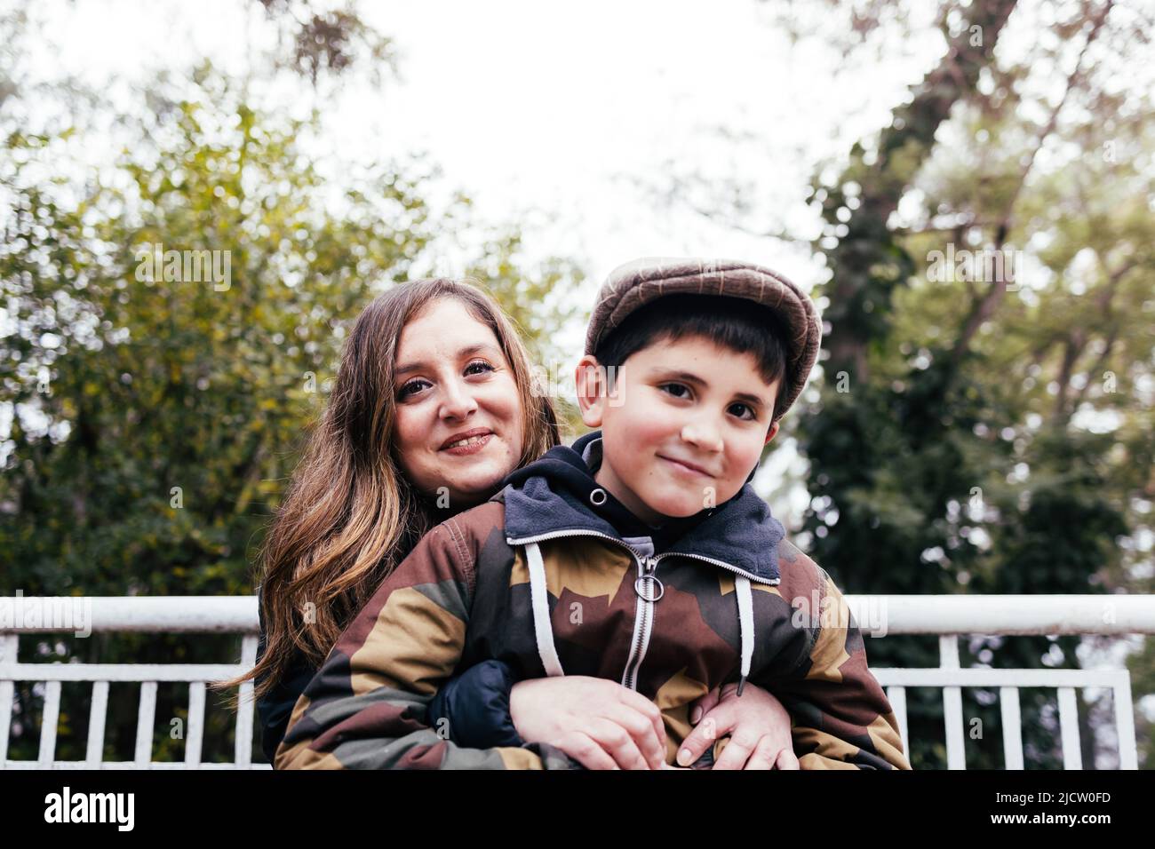 Mother hugging her young son in the park. Single parent family Stock Photo