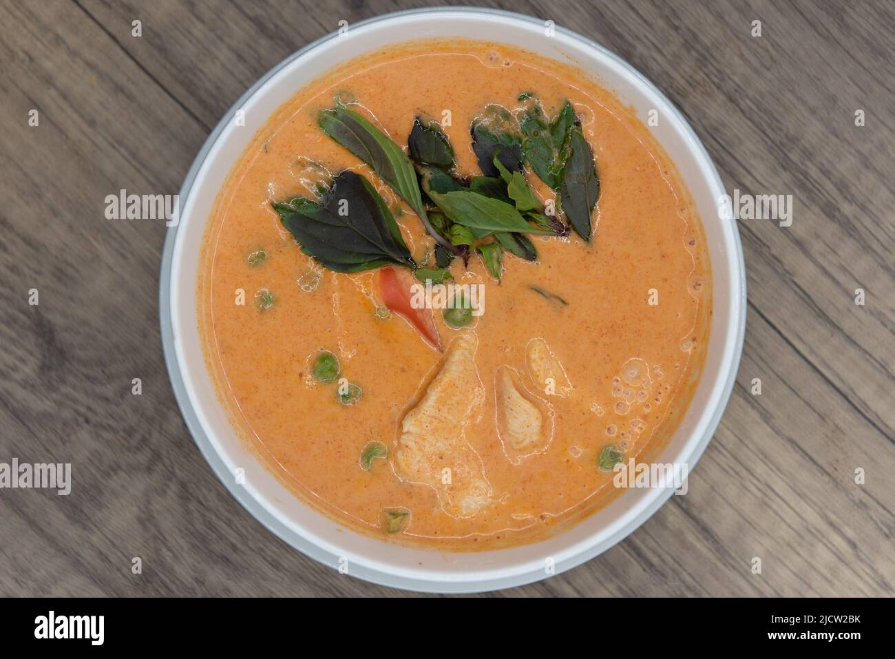 Overhead view of spicy Panang Curry with decorative garnishment served in a bowl and ready to eat. Stock Photo