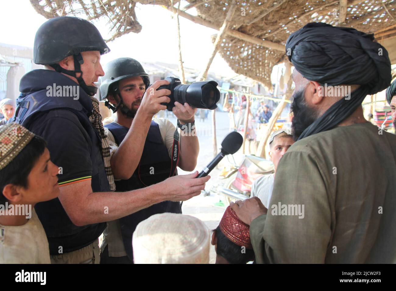 Al Jazeera news reporters interview a teacher at a local boys school in Kajaki, Helmond Province, Afghanistan. Stock Photo